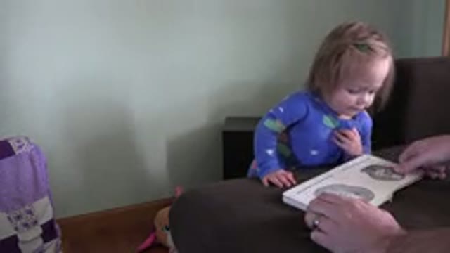WESTMINSTER COLORADO-2016: Little Girl Reads Children's Book While Man Browses