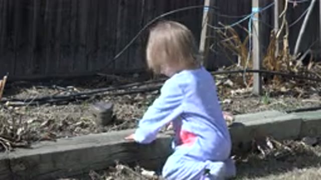 WESTMINSTER COLORADO-2016: Toddler Girl in Pajamas Playing with Rocks on a Curb