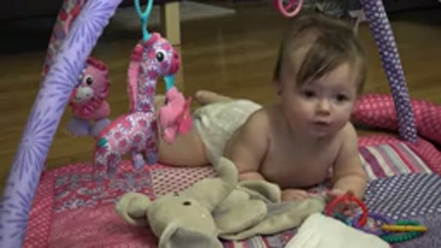 WESTMINSTER COLORADO-2015: Baby Girl Laying On A Pink-Violet Pattern Baby Gym