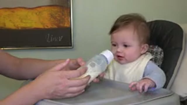 WESTMINSTER COLORADO-2015: Cute Baby Wearing a Bib Being Fed with a Bottle