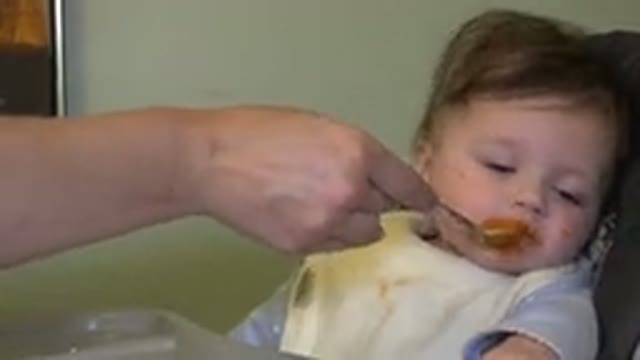 WESTMINSTER COLORADO-2015: A Child in a Bib Struggles to Eat During Mealtime