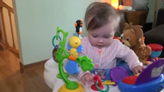 WESTMINSTER COLORADO-2015: A Small Baby Sitting In Pink Clothes Playing With Toys