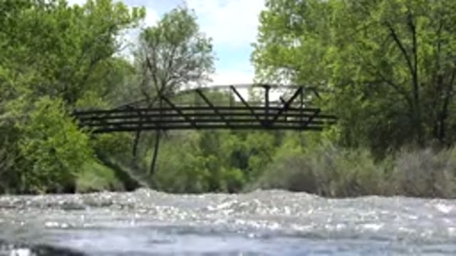 WESTMINSTER COLORADO-2015: A Person Riding a Bike Along a Riverside Path