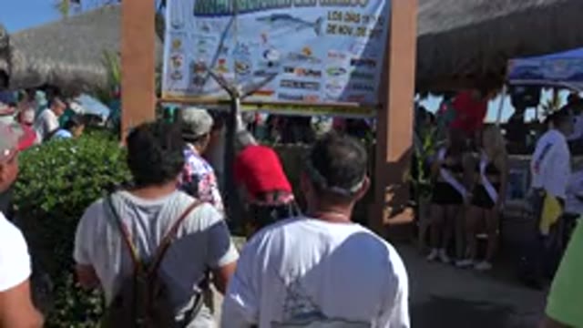 PLAYITA BCS MEXICO-2017: Crowd Gathered Around A Hanging Fish As A Man In Red