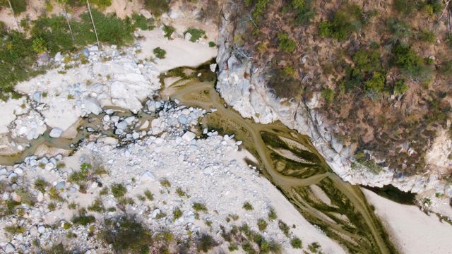 SAN DIONISIO BCS MEXICO-2023: Winding River Through Rocky Landscape From Above