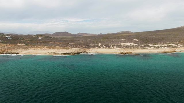 SHIPWRECKS EAST CAPE BCS MEXICO-2023: Waves Crashing on Rocky Shoreline with Sandy Beach