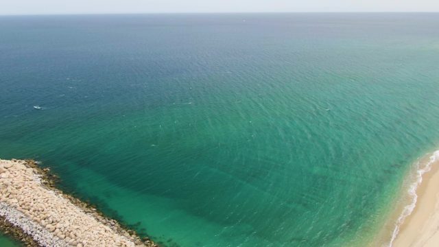 PUERTO LOS CABOS BEACH BCS MEXICO-2023: Coastal Breakwater with Turquoise Waters and Sandy Shore