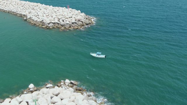 PUERTO LOS CABOS BEACH BCS MEXICO-2023: Boat Navigating Between Rocky Breakwaters