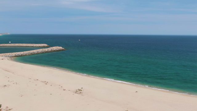 PUERTO LOS CABOS BEACH BCS MEXICO-2023: Sandy Beach and Ocean with Rocky Breakwater