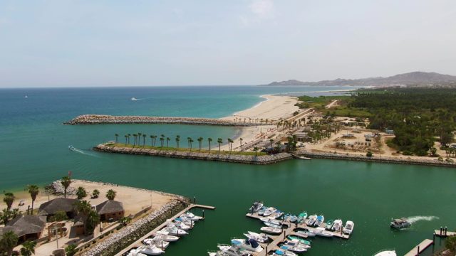 PUERTO LOS CABOS BEACH BCS MEXICO-2023: Boat Moving Through Marina near Sandy Beach