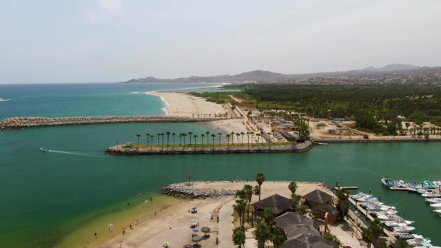 PUERTO LOS CABOS BEACH BCS MEXICO-2023: Coastal Boat Moving Past Beach and Marina