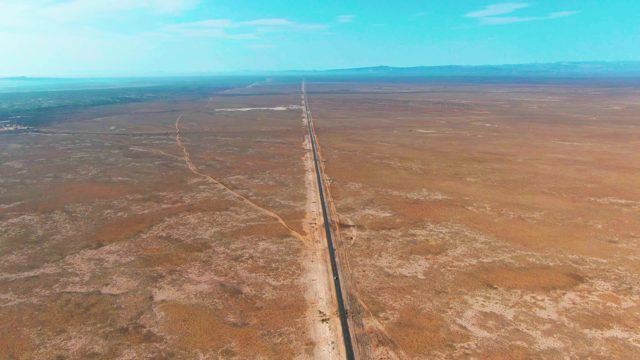 GUERRERO NEGRO BCS MEXICO-2022: Straight Desert Road Extending to Distant Mountains