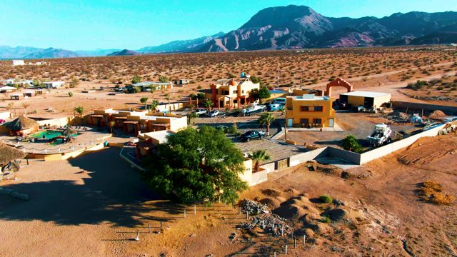 BAHIA DE LOS ANGELES BCS MEXICO-2022: Aerial Pan of Desert Town and Mountain Range