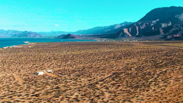 BAHIA DE LOS ANGELES BCS MEXICO-2022: Vehicle Traversing Arid Plain near Coastal Mountains