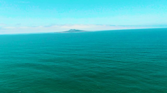 SAN QUINTIN BC MEXICO-2022: Distant Island on Calm Turquoise Ocean