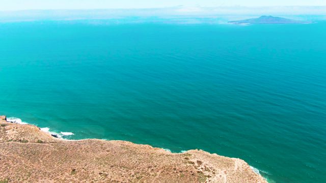 SAN QUINTIN BC MEXICO-2022: Cliff Overlooking Turquoise Sea and Distant Island