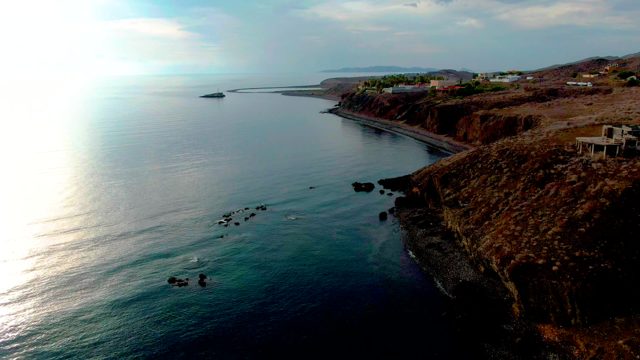 SANTA ROSALIA BCS MEXICO-2022: Rocky Coastline with Ocean Waves and Cliffside Buildings