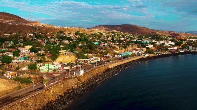 SANTA ROSALIA BCS MEXICO-2022: Coastal Road Traffic Passing Hillside Settlement