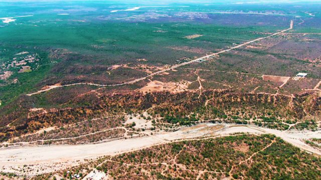 CADUANO BCS MEXICO-2022: River and Road Winding Through Hilly Landscape