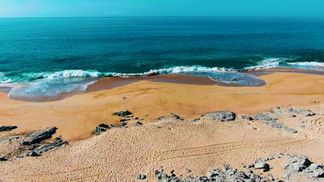 PUNTA BUZZARDS EAST CAPE BCS MEXICO-2022: Waves Crashing on Sandy Beach with Rocky Outcrops