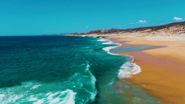 PUNTA BUZZARDS EAST CAPE BCS MEXICO-2022: Waves Crashing on Sandy Shore with Turquoise Water