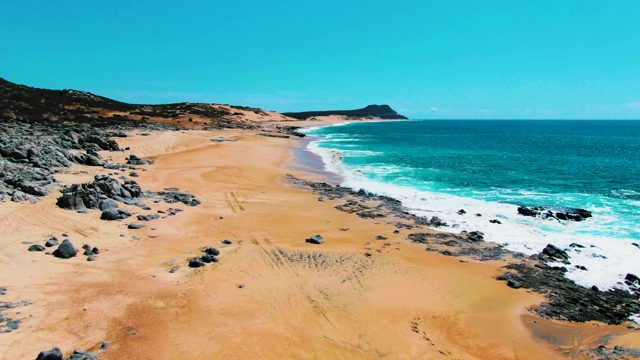 PUNTA BUZZARDS EAST CAPE BCS MEXICO-2022: Waves Crashing on Sandy Shore with Rocky Outcrops
