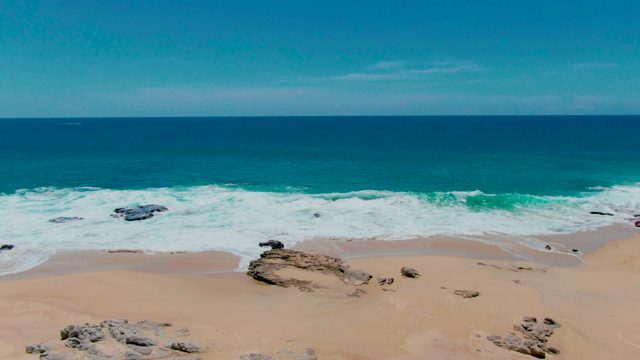 PUNTA BUZZARDS EAST CAPE BCS MEXICO-2022: Ocean Waves Crashing on Sandy Beach with Rocks