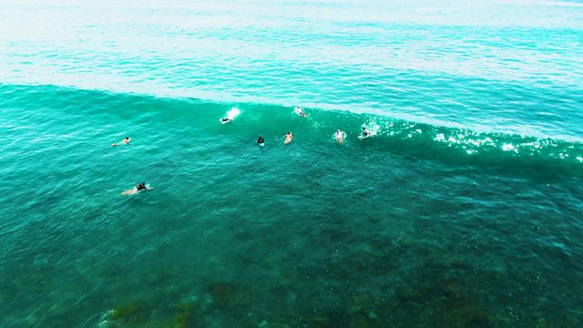 PUNTA BUZZARDS EAST CAPE BCS MEXICO-2022: Surfers Waiting for a Breaking Wave in Clear Ocean Water