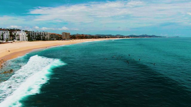 PUNTA BUZZARDS EAST CAPE BCS MEXICO-2022: Beachgoers in Ocean As Wave Approaches Shore