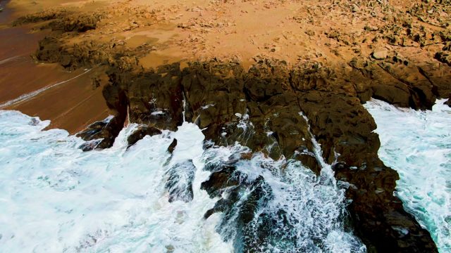 PUNTA BUZZARDS EAST CAPE BCS MEXICO-2022: Waves Crashing Against Rocky Coastline with Sandy Beach