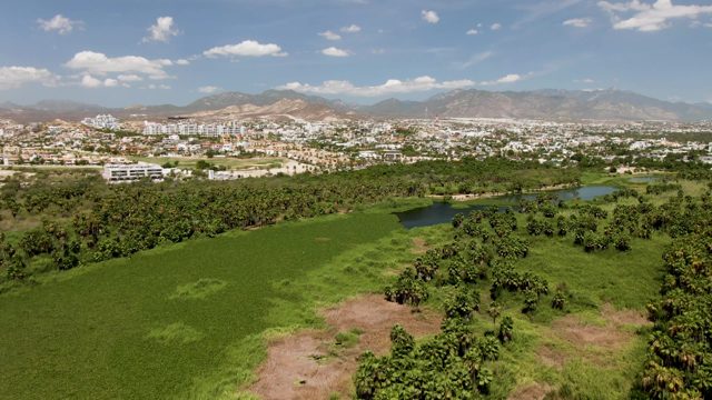 SAN JOSE DEL CABO BCS MEXICO-2022: Aerial Pan of Green Fields and Distant Town