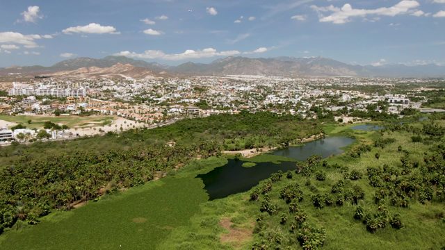 SAN JOSE DEL CABO BCS MEXICO-2022: Cityscape with Green Fields and Small Water Body