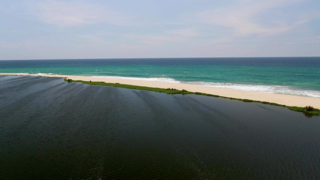 Waves Crashing on Sandy Shore with Lagoon