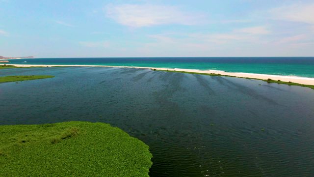 Shrinking Green Island Near Ocean Sandbar