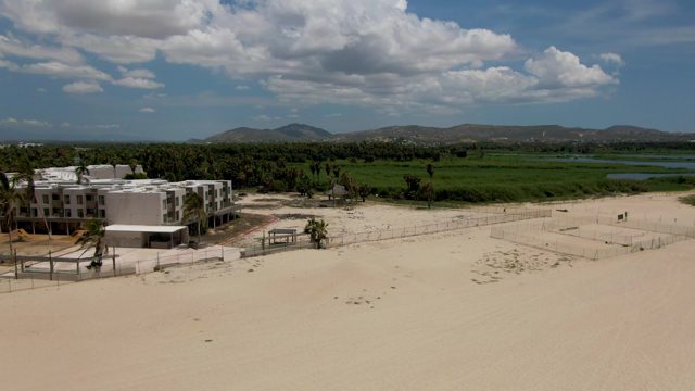 Sandy Beach with Buildings and Moving People