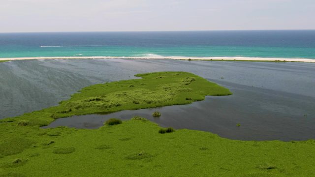 Coastal Lagoon and Turquoise Ocean with Moving Boat