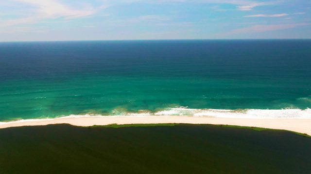 Ocean Waves Rolling and Breaking on White Sand Beach