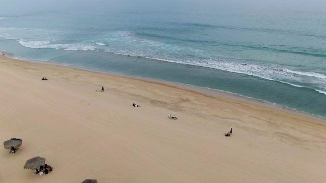 Sandy Beach with Vanishing Umbrellas and Moving People