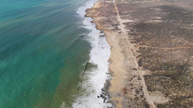 PUNTA GORDO EAST CAPE BCS MEXICO-2022: Waves Crashing Along Sandy Shore and Dirt Road