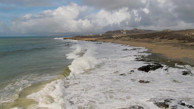 PUNTA GORDO EAST CAPE BCS MEXICO-2022: Waves Crashing on Sandy Shore with Rocky Outcrops