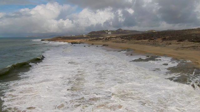 PUNTA GORDO EAST CAPE BCS MEXICO-2022: Waves Crashing Onto a Sandy Beach with Rocky Outcrops