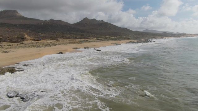 PUNTA GORDO EAST CAPE BCS MEXICO-2022: Waves Crashing on Rocky Shore with Distant Mountains