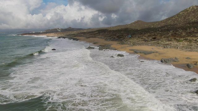 PUNTA GORDO EAST CAPE BCS MEXICO-2022: Waves Crashing Onto Sandy Shore with Rocky Outcrops