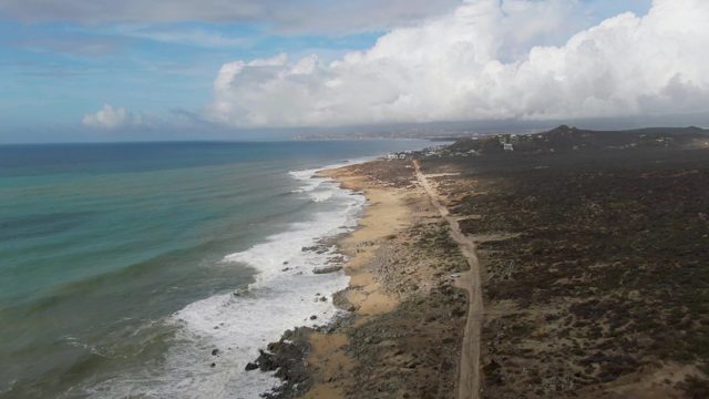 PUNTA GORDO EAST CAPE BCS MEXICO-2022: Waves Crashing Along Sandy Shore and Coastal Road