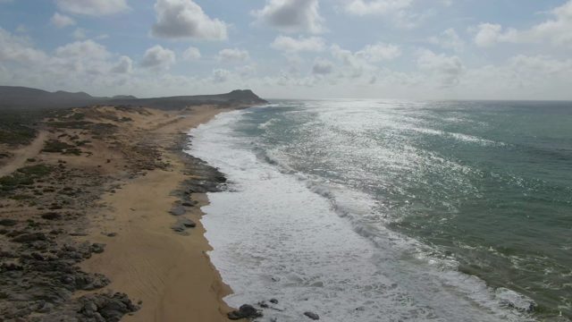 PUNTA GORDO EAST CAPE BCS MEXICO-2022: Waves Crashing on Sandy Shore with Rocky Outcrops