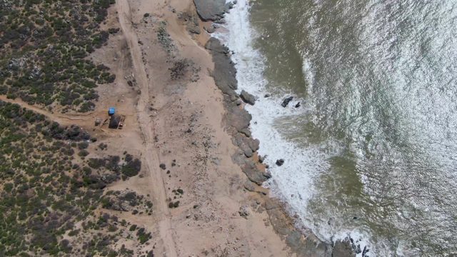 BUZZARDS EAST CAPE LOS CABOS BCS MEXICO-2022: Ocean Waves Crashing Against Rocky Shore on Sandy Beach