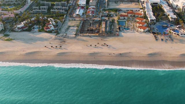 SAN JOSE DEL CABO BCS MEXICO-2022: Shifting Sand and Gentle Waves Along a Coastal Beach