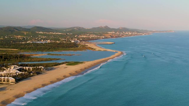 SAN JOSE DEL CABO BCS MEXICO-2022: Sandy Beach and Ocean with Moving Boat and Gentle Waves