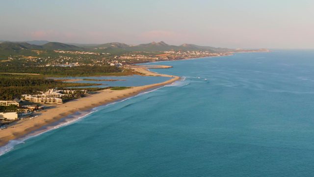 SAN JOSE DEL CABO BCS MEXICO-2022: Sandy Coastline with Boat Moving in Turquoise Waters