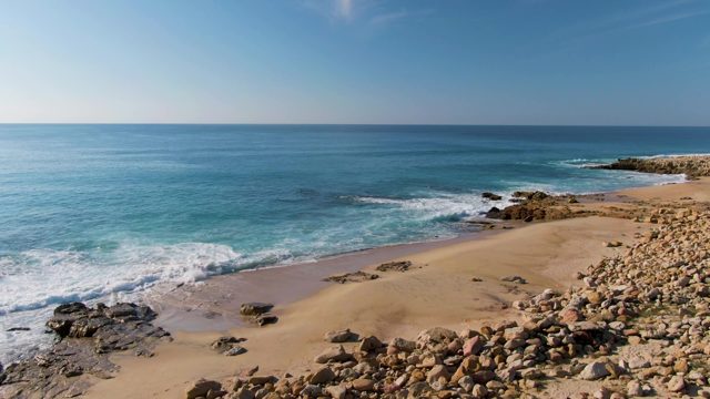 BUZZARDS EAST CAPE LOS CABOS BCS MEXICO-2022: Waves Crashing on Sandy Beach with Rocky Shores